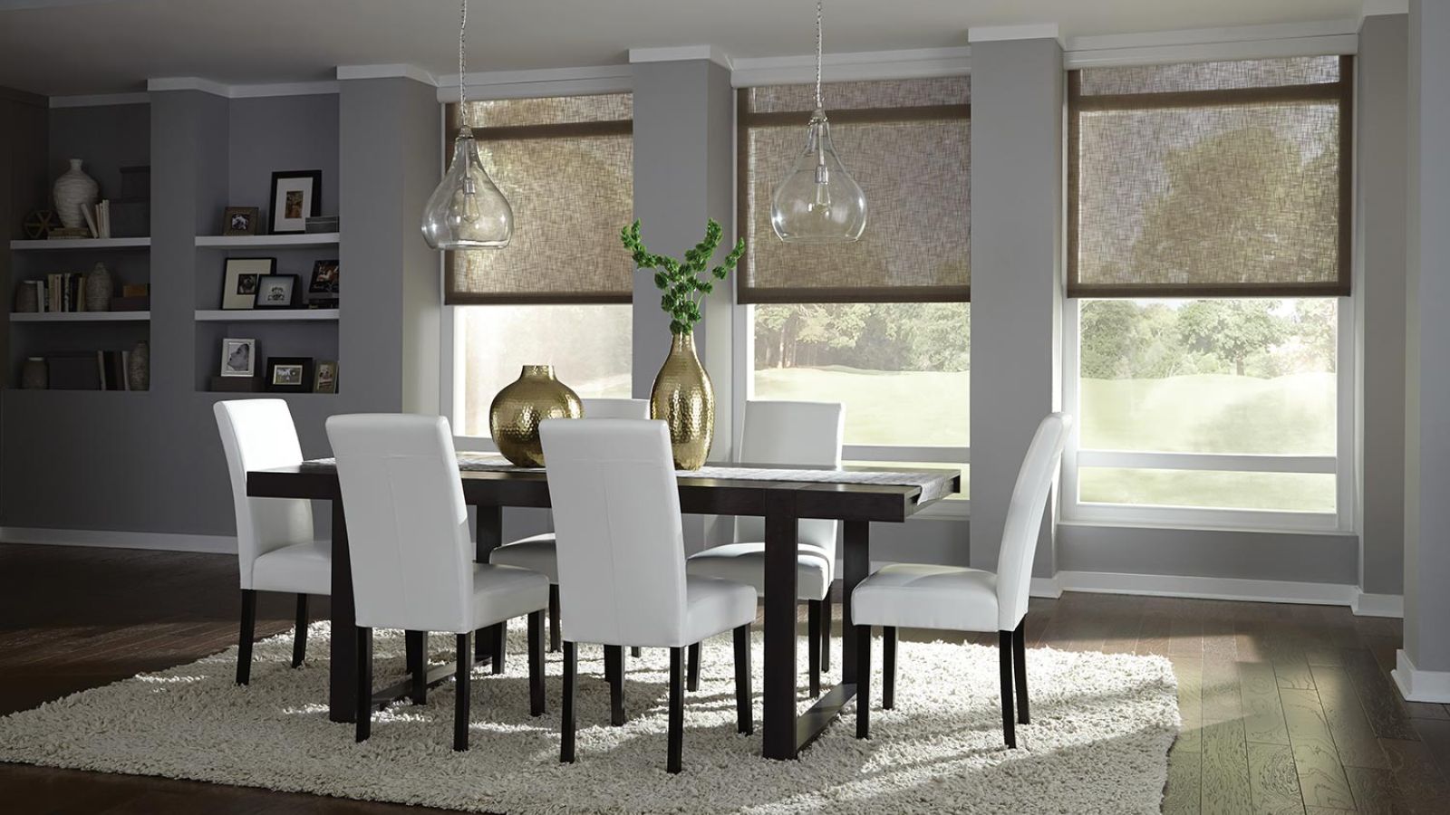 A modern dining room with white chairs, a black dining table, and soft light filtering through neutral fabric window shades.