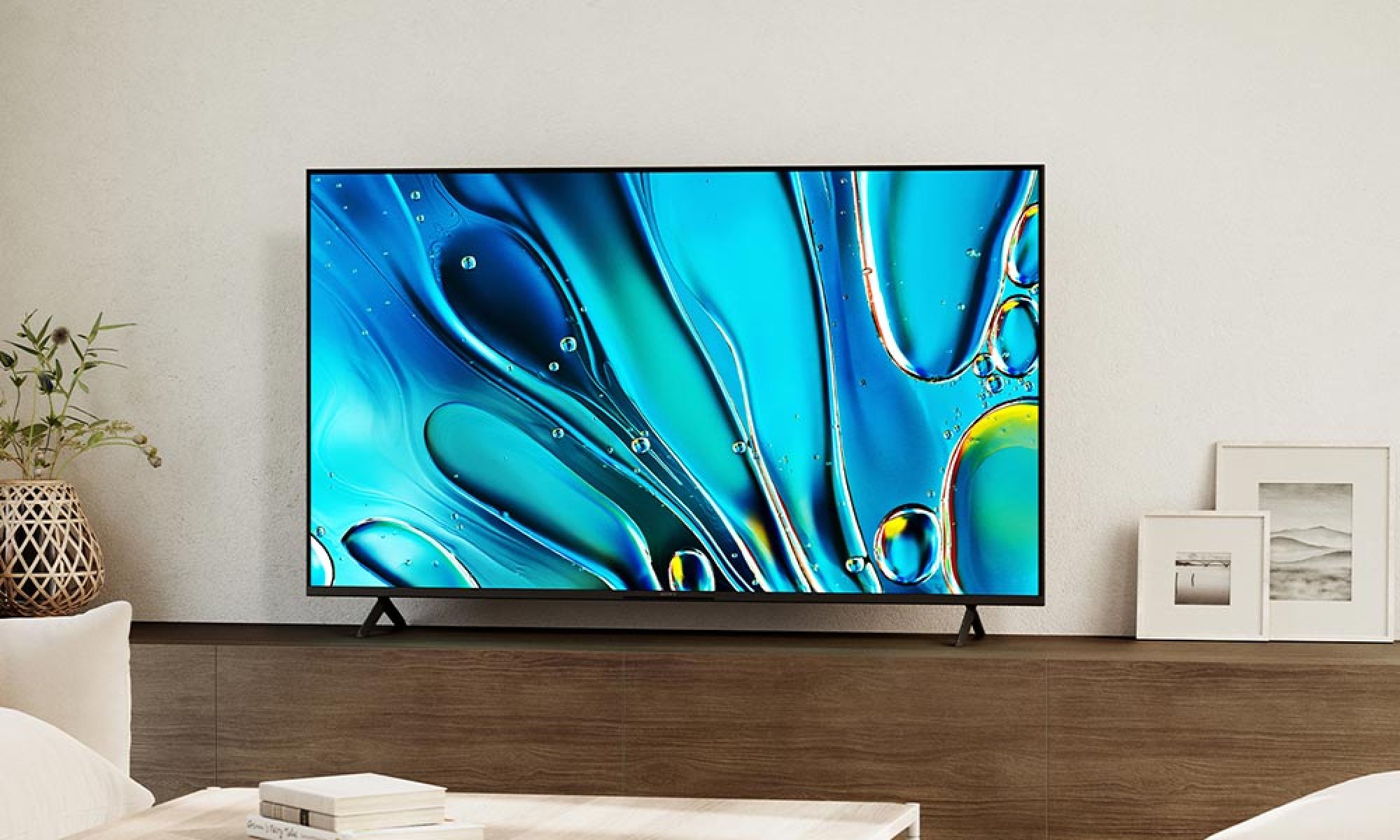 A high-definition television displaying a vibrant abstract pattern, mounted on a minimalist entertainment wall.