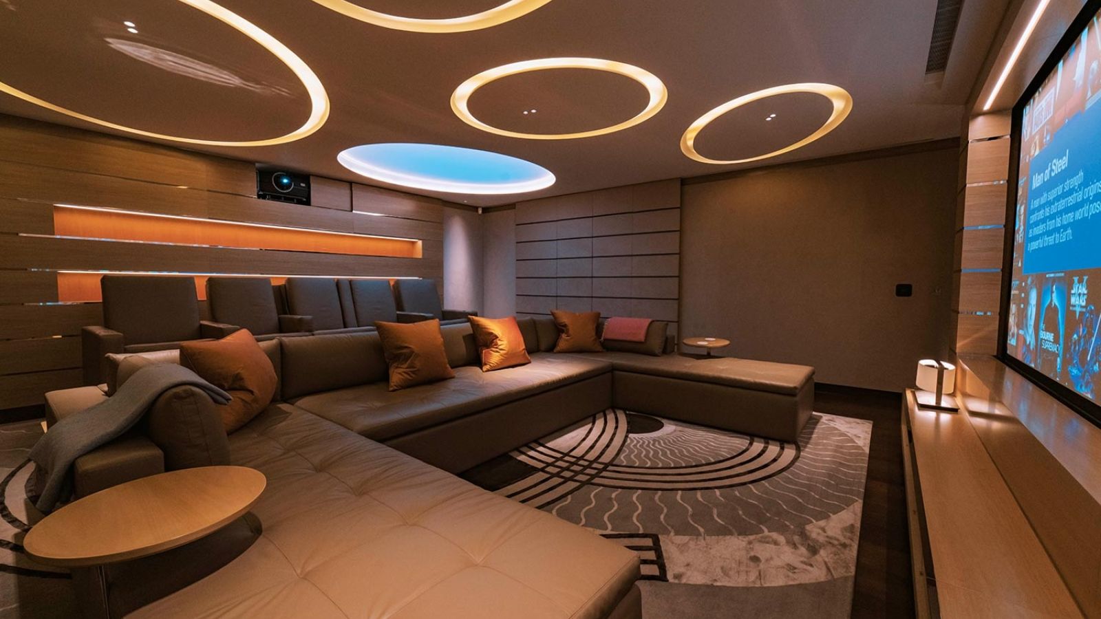 Modern theater with circular ceiling lights, cozy recliners, and an inviting seating arrangement.