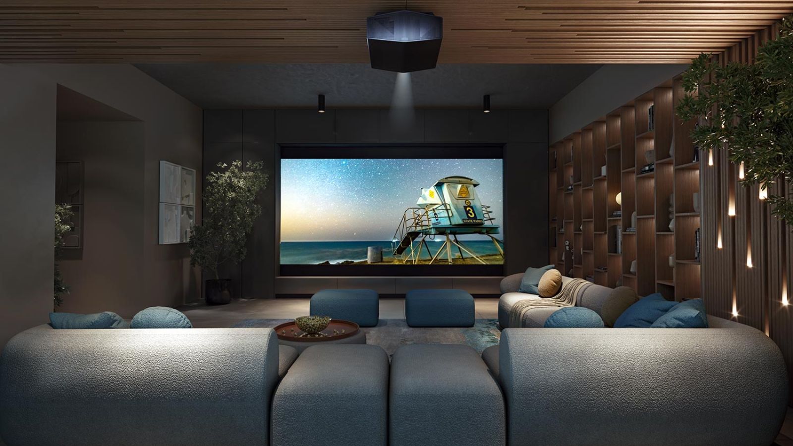 Cozy media room with blue furniture, a wooden ceiling, and a starry beach scene on the screen.