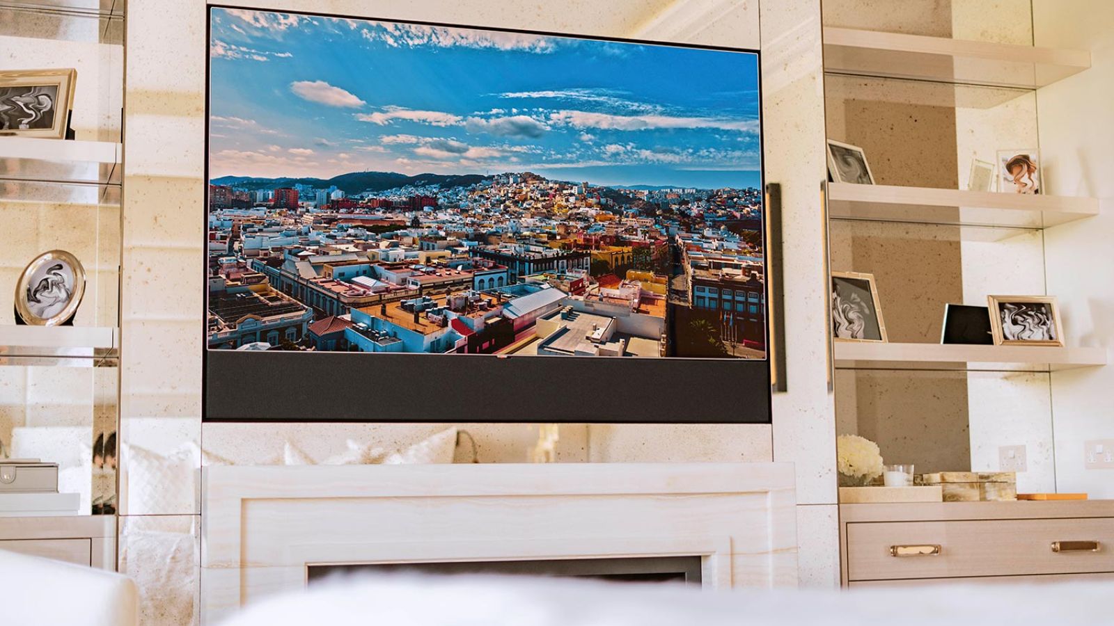 Sophisticated room with a TV surrounded by glass shelving and scenic urban views in the background.