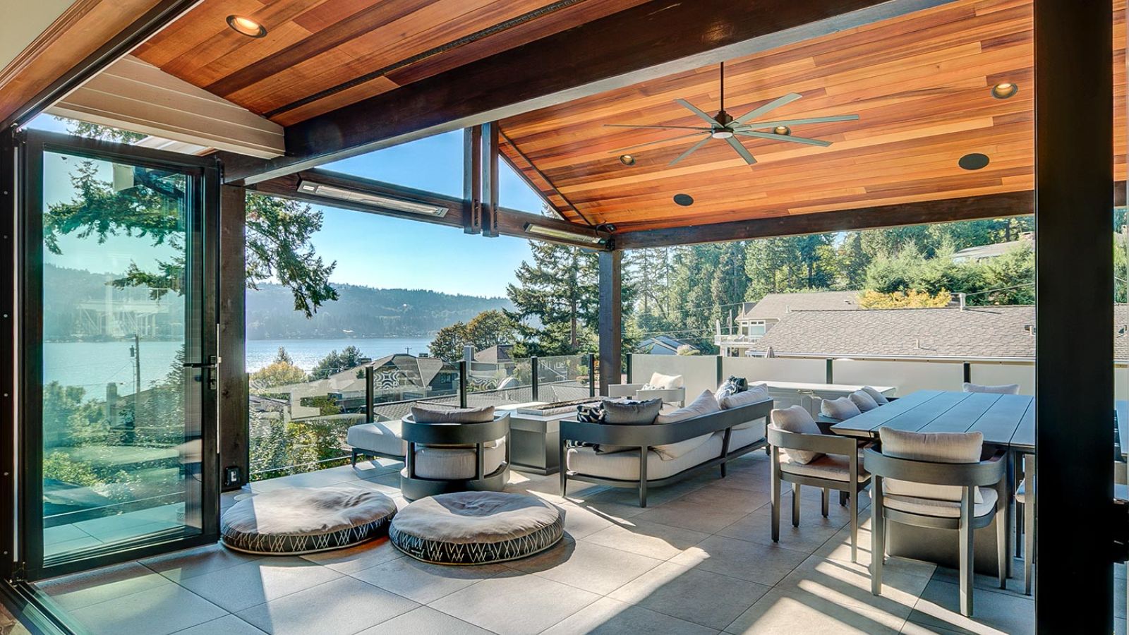 Covered outdoor living area with open walls, comfortable seating, and a view of the water.